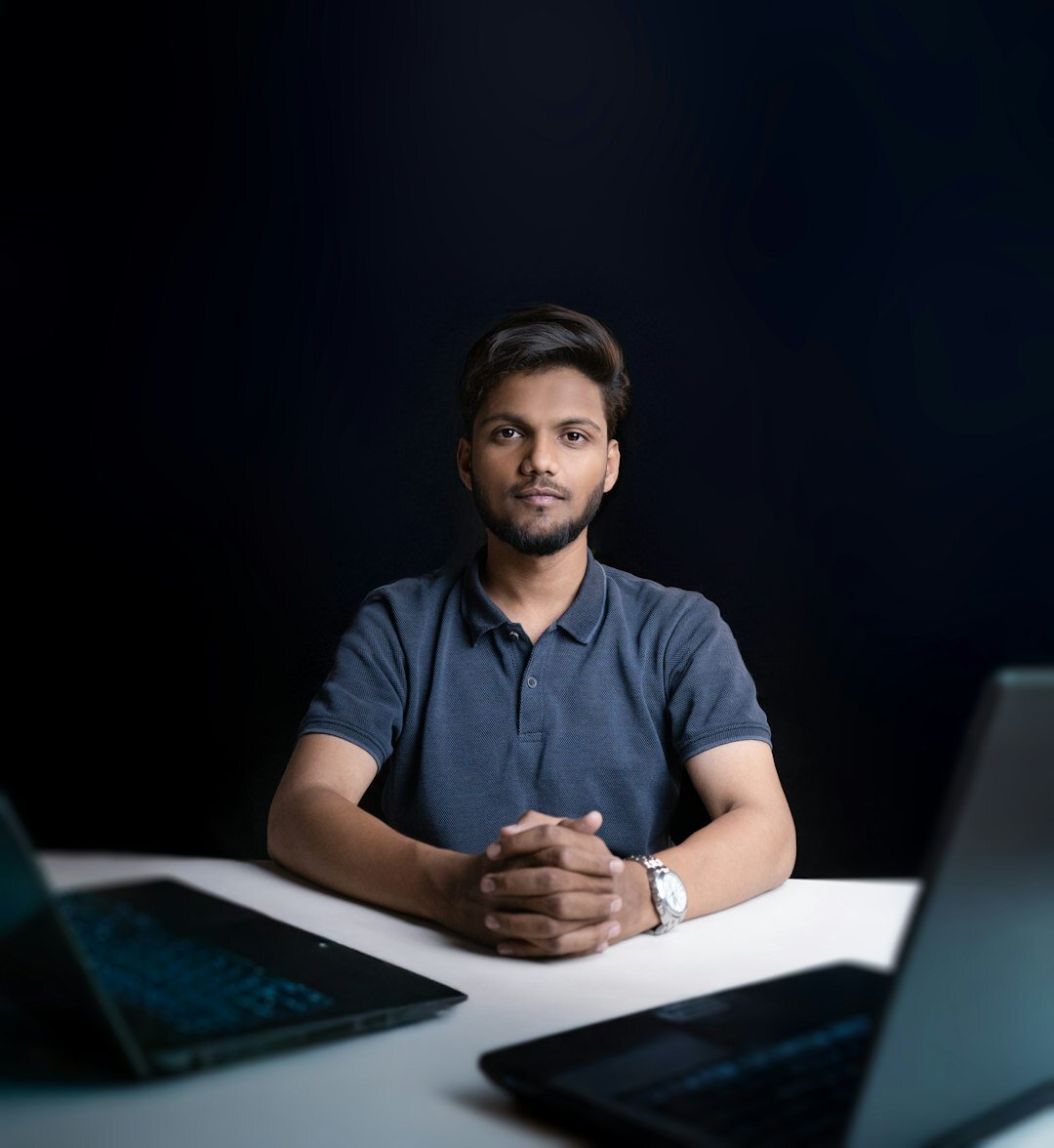 Portuguese software developer coding on a laptop at a desk