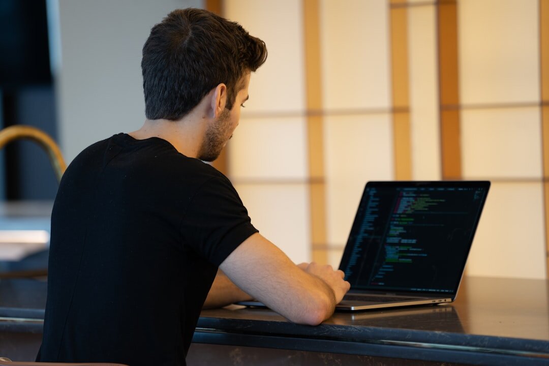 developer writing code on laptop